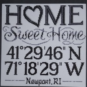 May include: Cross-stitch artwork with the words "HOME" and "Sweet Home" above coordinates 41°29'46" N and 71°18'29" W, with "Newport, RI" below. The design is in black and gray on a white background.
