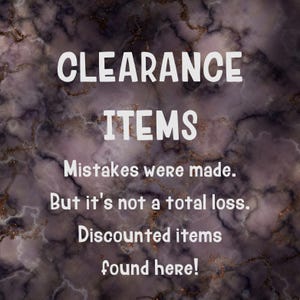 May include: A dark purple and black marble-patterned background with white text that reads: CLEARANCE ITEMS. Mistakes were made. But it's not a total loss. Discounted items found here! The design features subtle gold-toned veins throughout the surface.