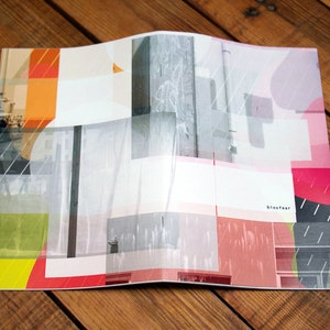 May include: A colorful abstract design with geometric shapes and overlapping layers. The design features a variety of colors, including red, orange, yellow, green, blue, and pink. The text "blockwear" is visible in the lower right corner.