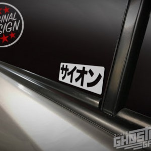 May include: A white sticker with black text that says "サイオン" on a black car window.