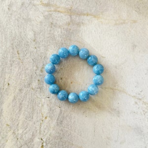 K&ouml;nnte beinhalten: Ein hellblaues Edelstein-Armband mit runden Perlen.