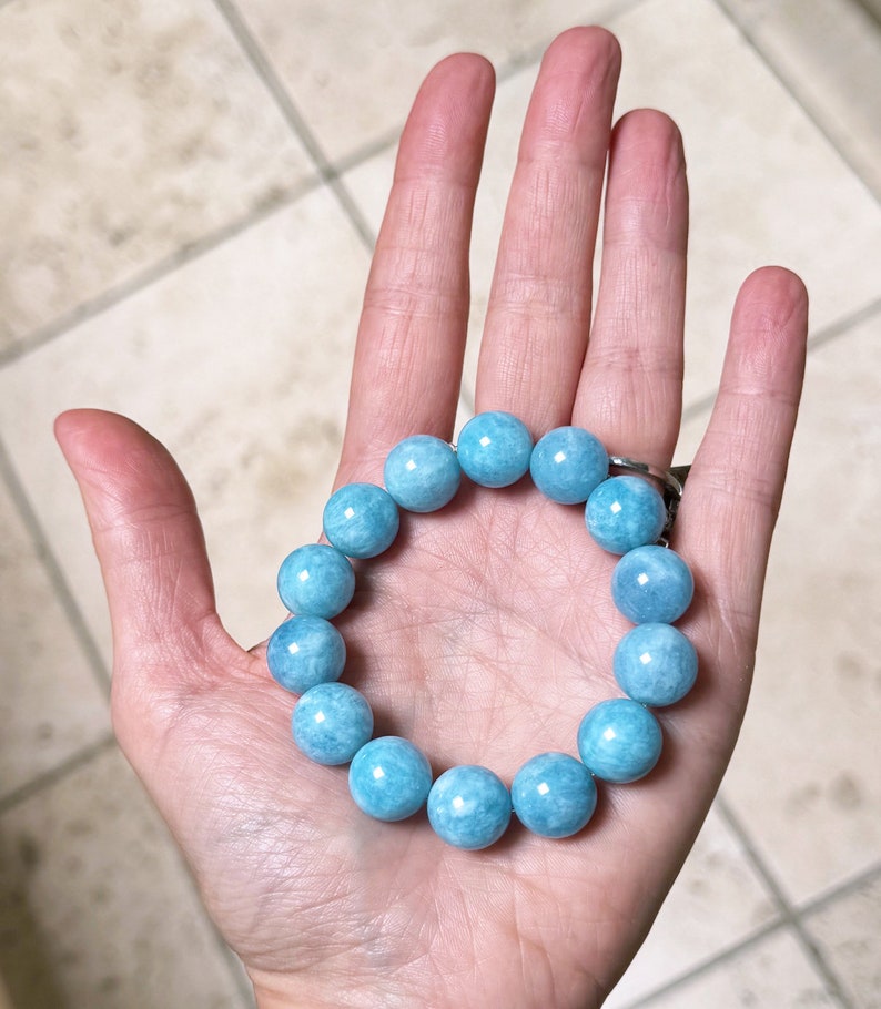 K&ouml;nnte beinhalten: Ein hellblaues Edelstein-Armband mit runden Perlen. Das Armband besteht aus Aquamarin-Steinen.