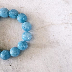 K&ouml;nnte beinhalten: Ein hellblaues Edelstein-Armband mit runden Perlen.