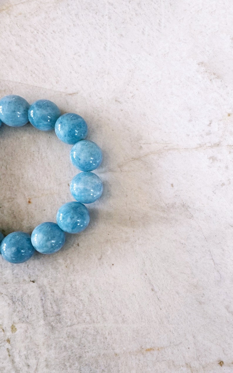 K&ouml;nnte beinhalten: Ein hellblaues Edelstein-Armband mit runden Perlen.