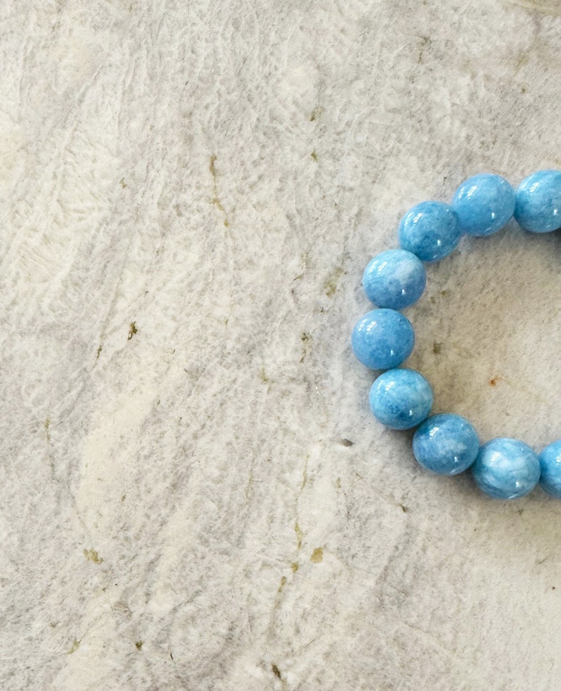 K&ouml;nnte beinhalten: Ein hellblaues Edelstein-Armband mit runden Perlen.