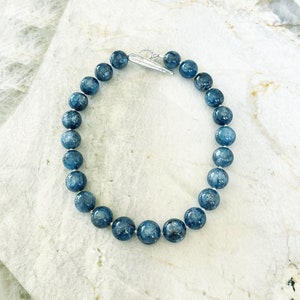 K&ouml;nnte beinhalten: Eine Halskette aus blauen Edelsteinen mit einem silbernen Verschluss. Die Halskette besteht aus runden Perlen und ist etwa 45 cm lang.
