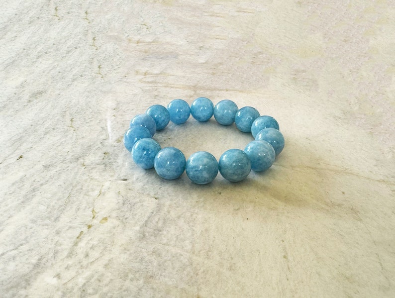K&ouml;nnte beinhalten: Ein hellblaues Aquamarin-Armband mit runden Perlen.