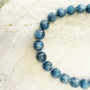 K&ouml;nnte beinhalten: Ein blaues Edelstein-Armband mit runden Perlen. Die Perlen sind hellblau mit einem leicht dunkleren Blauton.