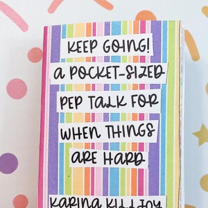 Peut inclure: Un petit livre ray&eacute; color&eacute; avec le texte "KEEP GOING! a POCKET-SIZED PEP TALK FOR WHEN THINGS ARE HARD" et le nom de l'auteur "KARINA KILLJOY FEMME FILTH PRESS".