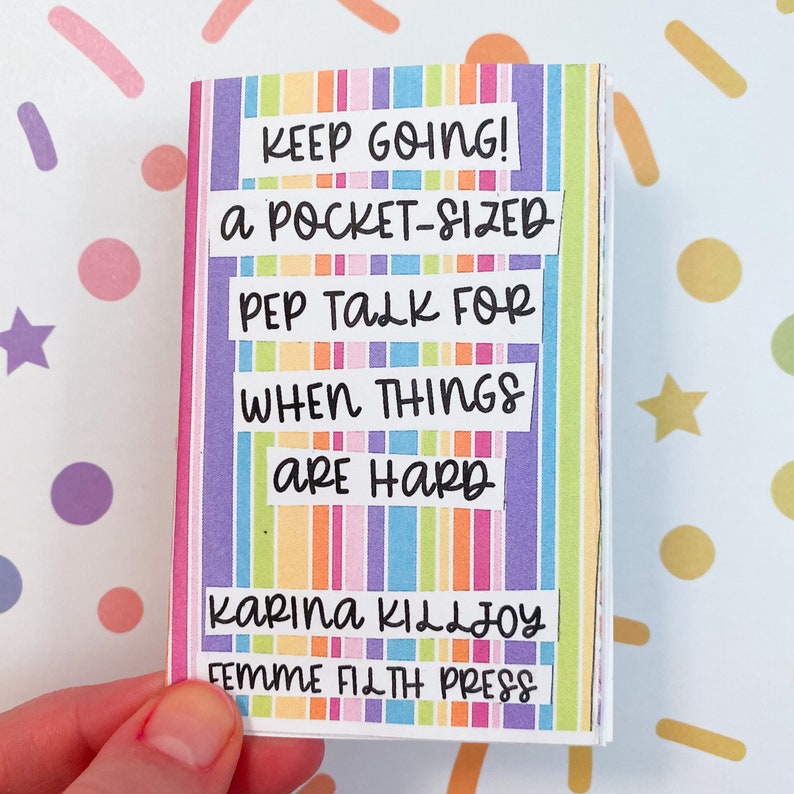 Peut inclure: Un petit livre ray&eacute; color&eacute; avec le texte "KEEP GOING! a POCKET-SIZED PEP TALK FOR WHEN THINGS ARE HARD" et le nom de l'auteur "KARINA KILLJOY FEMME FILTH PRESS".