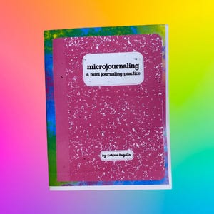 May include: A composition notebook with a pink cover and white speckles. The notebook has the text "microjournaling a mini journaling practice" in a white rectangle. The author's name, Karina Hazelin, is at the bottom.