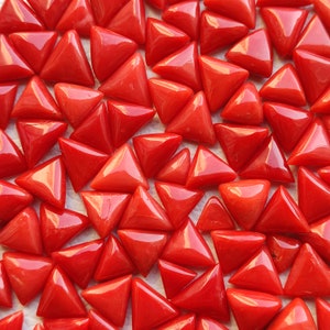 May include: A collection of red coral triangle shaped gemstones. The coral is a vibrant red color and the triangles are all different sizes.