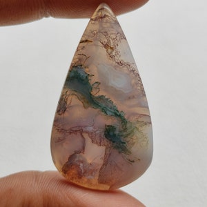 Peut inclure: Un cabochon d'agate en forme de larme avec un motif unique de brun, vert et blanc. La pierre a une apparence translucide et est parfaite pour la fabrication de bijoux.