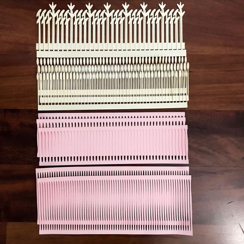 Puede incluir: Disposici&oacute;n de elementos de papel troquelado en crema y rosa. Las piezas de color crema tienen un borde superior decorativo y l&iacute;neas verticales. Las piezas rosas tienen un dise&ntilde;o similar a flecos. Estos recortes de papel son probablemente para manualidades o &aacute;lbumes de recortes.