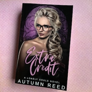 May include: Book cover with a woman wearing glasses and a braid. The title of the book is "Extra Credit" and the author is "Autumn Reed".