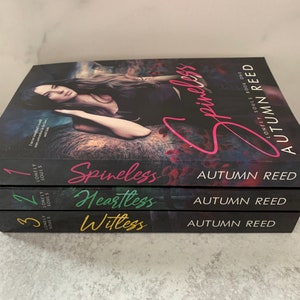 May include: A stack of three paperback books with black covers. The titles are "Spineless", "Heartless", and "Witless". The author is Autumn Reed. The books are part of a series called "Lonely Souls".