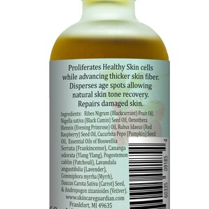 May include: A 60 ml (2 fl oz) amber glass bottle of facial oil with a silver lid. The label is white with green text and a barcode. The text on the label reads "Proliferates Healthy Skin cells while advancing thicker skin fiber. Disperses age spots allowing natural skin tone recovery. Repairs damaged skin. Ingredients: Ribes Nigrum (Blackcurrant) Fruit Oil, Nigella sativa (Black Cumin) Seed Oil, Oenothera Biennis (Evening Primrose) Oil, Rubus Idaeus (Red Raspberry) Seed Oil, Cucurbita Pepo (Pumpkin) Seed Oil, Essential Oils of Boswellia Serrata (Frankincense), Cananga odorata (Ylang Ylang), Pogostemon cablin (Patchouli), Lavandula angustifolia (Lavender), Commiphora myrrha (Myrrh), Daucus Carota Sativa (Carrot) Seed, & Andropogon zizanioides (Vetiver). www.skincareguardian.com Frankfort, MI 49635 60 ml (2 fl oz)"