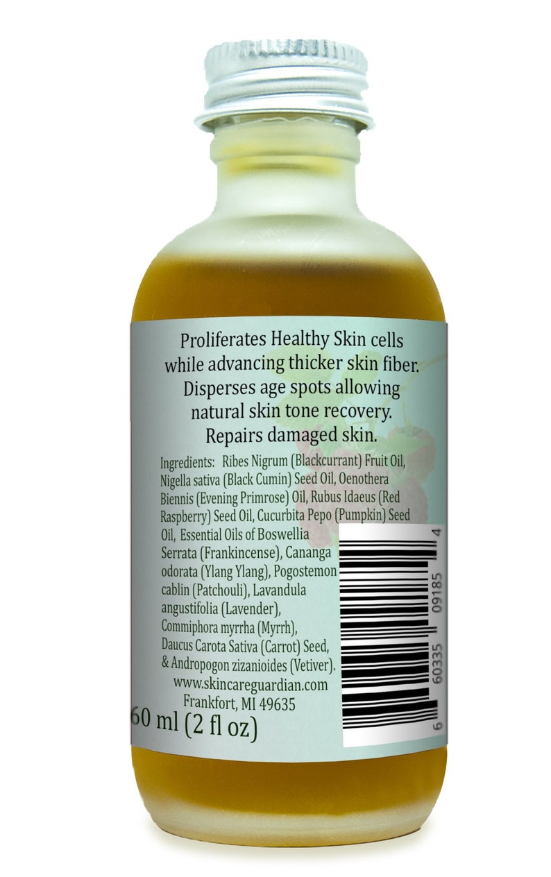 May include: A 60 ml (2 fl oz) amber glass bottle of facial oil with a silver lid. The label is white with green text and a barcode. The text on the label reads "Proliferates Healthy Skin cells while advancing thicker skin fiber. Disperses age spots allowing natural skin tone recovery. Repairs damaged skin. Ingredients: Ribes Nigrum (Blackcurrant) Fruit Oil, Nigella sativa (Black Cumin) Seed Oil, Oenothera Biennis (Evening Primrose) Oil, Rubus Idaeus (Red Raspberry) Seed Oil, Cucurbita Pepo (Pumpkin) Seed Oil, Essential Oils of Boswellia Serrata (Frankincense), Cananga odorata (Ylang Ylang), Pogostemon cablin (Patchouli), Lavandula angustifolia (Lavender), Commiphora myrrha (Myrrh), Daucus Carota Sativa (Carrot) Seed, & Andropogon zizanioides (Vetiver). www.skincareguardian.com Frankfort, MI 49635 60 ml (2 fl oz)"