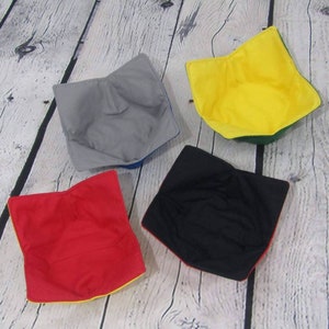 May include: Four fabric bowls in different colors: gray, yellow, red, and black. Each bowl has a contrasting colored trim.