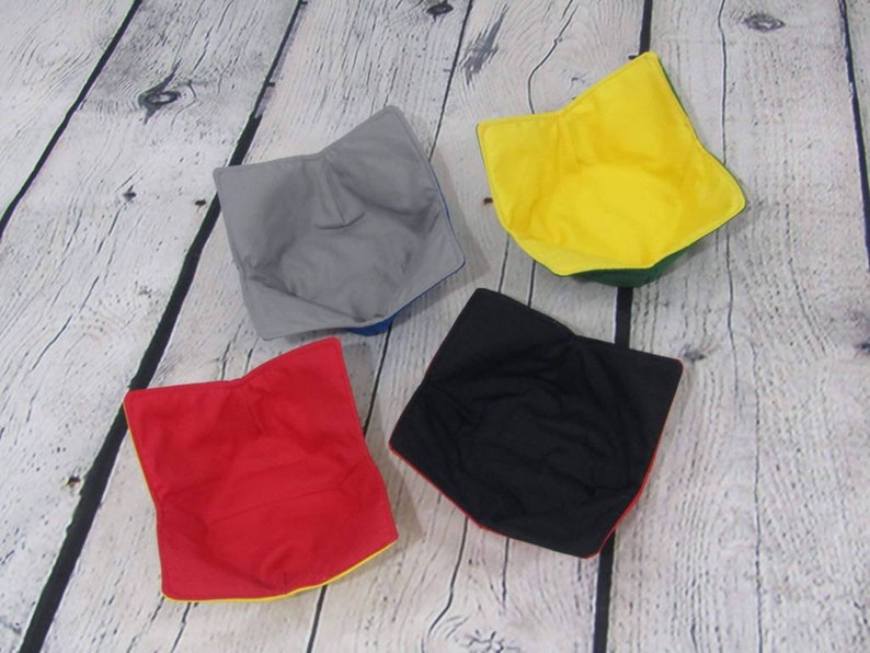 May include: Four fabric bowls in different colors: gray, yellow, red, and black. Each bowl has a contrasting colored trim.