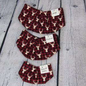 May include: Three red and black plaid fabric dog collars with white deer silhouettes. The collars are labeled with their sizes: 10" Large, 8" Medium, and 6" Regular (small).