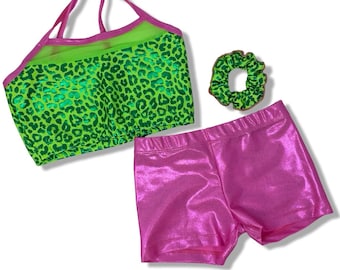May include: A three-piece set consisting of a neon green and black leopard print crop top with pink trim and straps, a pair of metallic pink athletic shorts, and a matching neon green and black leopard print fabric hair scrunchie.