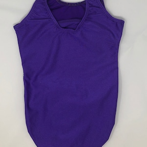 Puede incluir: Maillot de gimnasia morado liso con espalda escotada y tirantes. La ropa de gimnasia est&aacute; hecha de un material el&aacute;stico y est&aacute; dise&ntilde;ada para actividades deportivas. El maillot es de un tono morado vibrante.