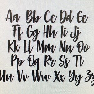 May include: Black cursive alphabet letters A to Z, arranged in a grid. The letters are in a handwritten style, with a slight slant and varying stroke thickness. The background is plain white.