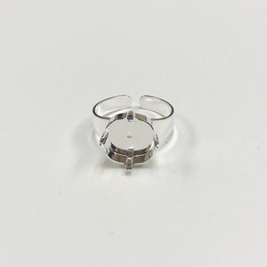 May include: Silver ring setting with a round bezel for a cabochon stone.