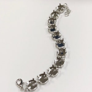 May include: Silver bracelet with a chain and multiple round settings for rhinestones or other embellishments.