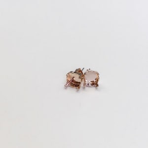 May include: A pair of rose gold earring settings with prongs. The settings are empty and ready to be filled with gemstones.