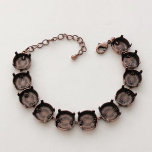 May include: A copper-toned bracelet with a chain closure and round settings for stones. The bracelet is made of metal and has a polished finish.