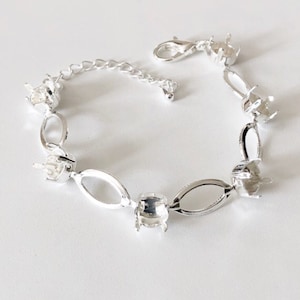 May include: Silver bracelet with oval links and settings for stones. The bracelet has a lobster clasp closure.