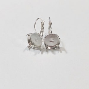 May include: A pair of silver earring settings with round bezels. The bezels are empty and ready to be filled with a stone or other embellishment.