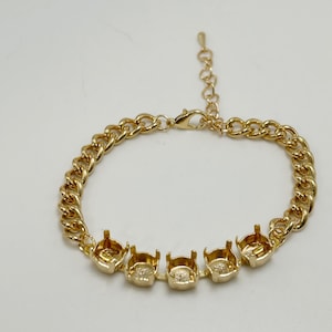May include: Gold-toned bracelet featuring a curb chain design. The bracelet includes five bezel settings for stones or embellishments. The adjustable chain allows for a customized fit. A stylish piece of jewelry.