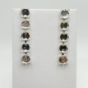 May include: A pair of silver earring blanks with five round settings for rhinestones or other embellishments.