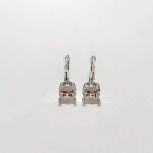 May include: A pair of leverback earrings with a silver-colored metal setting. Each earring features a square-cut, light pink gemstone. The earrings are displayed against a white background.