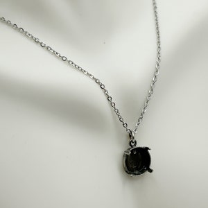 May include: A silver chain necklace with a silver pendant that has a round bezel setting. The bezel setting is empty and ready to be filled with a stone.