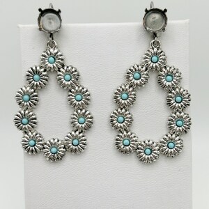 May include: A pair of silver-toned drop earrings. Each earring features a teardrop shape composed of small, daisy-like flowers with turquoise centers. The earrings have a post-style backing.