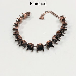 May include: A copper-toned bracelet with a chain and a series of open settings for adding rhinestones or other embellishments. The bracelet is labeled "Finished".