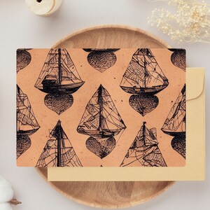 Puede incluir: Un patrón repetido de ilustraciones de veleros en blanco y negro sobre un fondo melocotón. Los veleros están estilizados y tienen una forma de corazón en la parte inferior de cada uno.