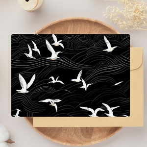 Puede incluir: Ilustración en blanco y negro de pájaros estilizados volando sobre un patrón ondulado blanco y negro. Los pájaros son blancos con contornos negros y las olas son blancas sobre un fondo negro.