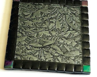 Posavasos de cristal gris/negro con efecto de brillo iridiscente, esquinas de cristal iridiscentes, borde llamativo.