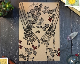 May include: A rectangular art print on tan paper featuring a detailed black ink illustration of two skeletal hands with fingers hooked together, surrounded by intricate black line-drawn vines, leaves, and small red flowers.