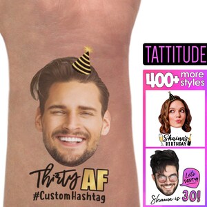 Op de afbeelding: Een tijdelijke tattoo met het gezicht van een man en de tekst "Thirty AF #CustomHashtag". De tattoo is op een roze achtergrond. De afbeelding toont ook een verscheidenheid aan andere tijdelijke tattoos met verschillende ontwerpen en tekst, waaronder "Shaina's Birthday" en "Shawn is 30!" De tekst "TATTITUDE 400+ more styles" is ook zichtbaar.