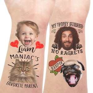Könnte beinhalten: Zwei temporäre Tattoo-Designs. Das erste Design zeigt das Gesicht eines Kindes mit dem Text "Liam Maniac's Favorite Parent" und das Gesicht einer Katze. Das zweite Design zeigt das Gesicht eines Mannes mit dem Text "My Trophy Husband No Ragrets" und das Gesicht eines Hundes mit einem Herz-Tattoo, auf dem "Nandor" steht.
