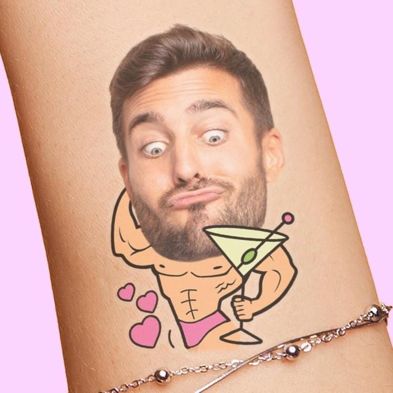 Image of a wrist with a custom face temporary tattoo adhered to it. The personalized face tattoo, often used for bachelorette parties or birthday party favors, features a cutout of a grooms face on a cartoon buff body that's flexing, holding a giant martini and wearing a bikini bottom. Design also features hearts and has space to add the grooms name as well.