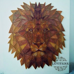 May include: A geometric lion's head made of string art. The lion is depicted in shades of brown, gold, and red. The artwork is signed "LEVITANA" in the bottom right corner.
