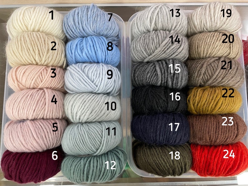 Puede incluir: Veinticuatro ovillos de lana en varios colores, incluyendo blanco, azul claro, rosa, rojo, marr&oacute;n y negro. Cada ovillo est&aacute; etiquetado con un n&uacute;mero del 1 al 24.