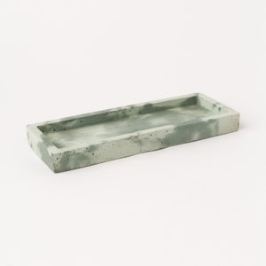 May include: A long, rectangular tray made of concrete with a light green and grey marbled finish.